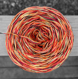 Black, red, yellow, and orange cotton variegated yarn.